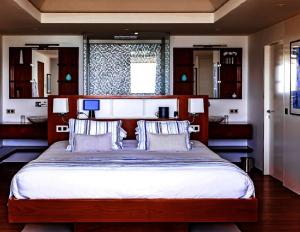 a bedroom with a large wooden bed with two pillows at Tropical heaven in Les Trois-Îlets