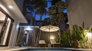 a patio with an umbrella next to a swimming pool at 3BR Private Pool Villa in Central Seminyak - Walk to Cafés & Shops in Seminyak