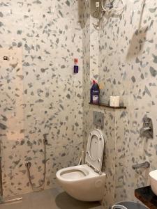 a bathroom with a toilet and a sink in a room at OddbirdStays in Indore +15 photos