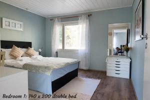 a bedroom with a bed and a window at Lumi & Luonto - Entire 100 sqm 3-BR house with private wood fired sauna in Oulu