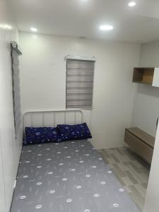 a small room with a bed and a window at Charming 2-Bedroom Balanga Getaway with Ample Space in Balanga +4 photos