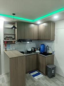 a kitchen with wooden cabinets and a green light at Charming 2-Bedroom Balanga Getaway with Ample Space in Balanga