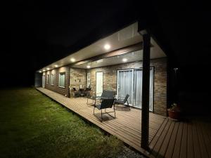 a house with a wooden deck at night at Acogedora Casa Los Canelos in Puerto Varas