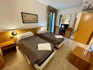 a hotel room with two beds and a television at Hotel Oasi Este in Este