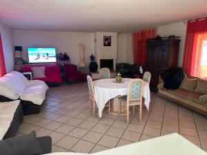 a living room with a table and a tv at Le paradis de la Provence in Verenay