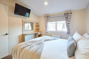 a bedroom with a bed with a tv on the wall at Host and Stay - 421 Wooler Park in Wooler