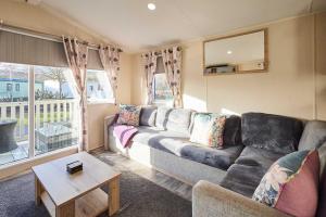 a living room with a couch and a table at Host and Stay - 421 Wooler Park in Wooler