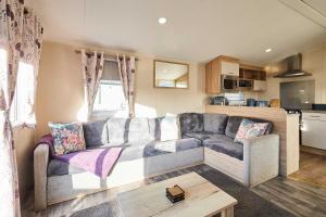 a living room with a couch and a kitchen at Host and Stay - 421 Wooler Park in Wooler