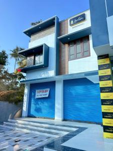 a building with two garage doors with a sign on it at Sunshine Holidays in Varkala