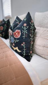 a black pillow with flowers on a bed at The BnB filled to the brim with character & charm! in Dubbo +78 photos