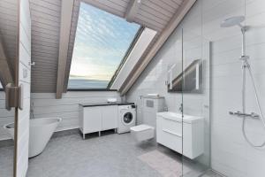 a bathroom with a shower toilet and a window at Naava Chalet 401 Penthouse - Järvinäköala ilta-aurinkoon in Ähtäri +27 photos