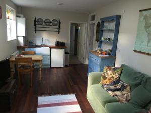 a living room with a green couch and a kitchen at North Street annexe in Ilminster