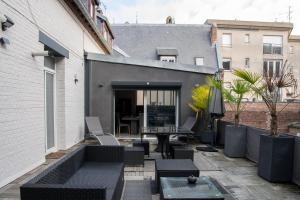 a patio with a table and chairs on a building at Le Saint-Quentin - Studio avec Terrasse in Saint-Quentin