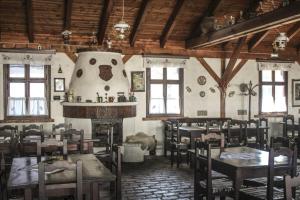 ein Restaurant mit Tischen und Stühlen und einem Kamin in der Unterkunft Central Chalet in Vărşag
