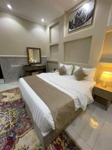 a bedroom with a large white bed and a television at غولدن إليت للشقق المخدومة الأجاويد Golden Elite Serviced apartment alajawed in Jeddah +25 photos