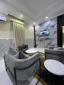 a living room with couches and tables and a tv at غولدن إليت للشقق المخدومة الأجاويد Golden Elite Serviced apartment alajawed in Jeddah
