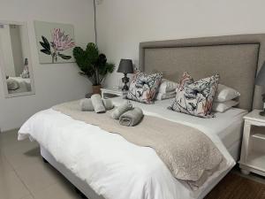 a bedroom with a large white bed with pillows at Ndlovu Addo River Lodge in Kirkwood