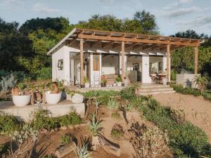 a small white house with a pergola at Ndlovu Addo River Lodge in Kirkwood