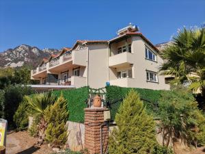 a building on a hill with trees and plants at Turunç Barbaros Apart in Marmaris