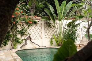 a swimming pool in a garden with plants at Pachamama Pool Villa in Gili Islands
