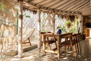 a wooden table and chairs on a patio at Pachamama Pool Villa in Gili Islands