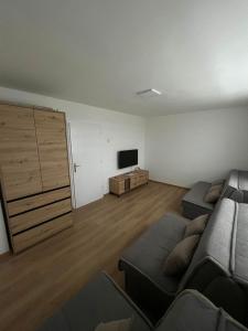 a living room with a couch and a flat screen tv at Stan na dan Žabac in Vlasenica +1 photo