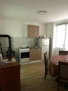 a kitchen with a table and a kitchen with a stove at Stan na dan Žabac in Vlasenica