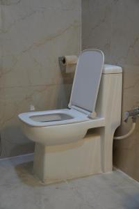 a toilet with the lid up in a bathroom at Yatindra Ashraya in Etāwah +25 photos