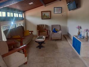 a living room with a couch and two chairs at Pousada Preludio in Conservatória