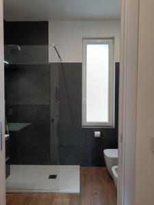 a bathroom with a glass shower and a toilet at Orelli House - Bilocal Garden in Lissone +34 photos