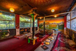 a living room with a table in a train room at Himtrek Riverside Camps, Kasol in Kasol
