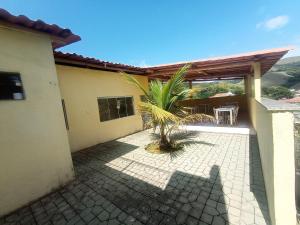 a patio of a house with a palm tree at Pousada Preludio in Conservatória
