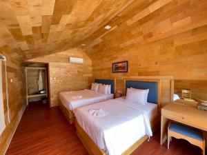 two beds in a room with wooden walls at Royal C Resort in Koh Rong Island +27 photos