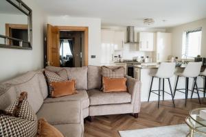 a living room with a couch and a kitchen at MD Stays in Portstewart