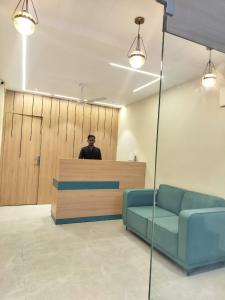 a man standing behind a counter in an office at Kubo by Convivial Hotels in Raipur
