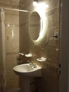 a bathroom with a sink and a mirror at Caleta Austral - dptos in Las Grutas +26 photos