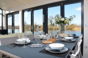 a dining room table with a blue table cloth and glasses at Riverside Lodge in Brundall