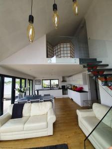 a living room with a white couch and a kitchen at Riverside Lodge in Brundall +20 photos