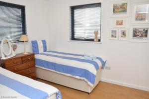 a bedroom with two beds and a window at Riverside Lodge in Brundall