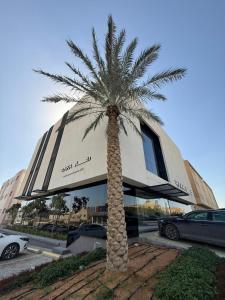 a palm tree in front of a building with cars at Rafa Hotel Apart in Riyadh