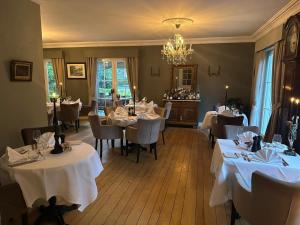 a restaurant with white tables and chairs and a chandelier at maison Clavita in Genk +16 photos