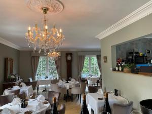 a dining room with white tables and a chandelier at maison Clavita in Genk
