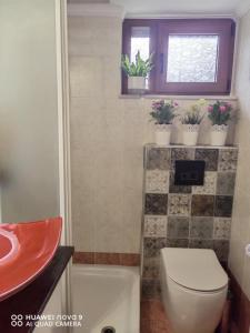 a bathroom with a toilet and a sink with potted plants at AVRA House in Karfas +15 photos