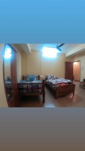 a room with two beds and a mirror at Hotel Pelican in Kalimpong +4 photos