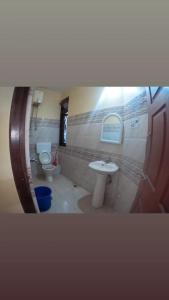 a bathroom with a toilet and a sink at Hotel Pelican in Kalimpong