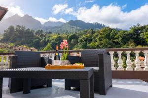 a table on a balcony with a view of mountains at View to the Valley, By OP in Senhora do Rosário
