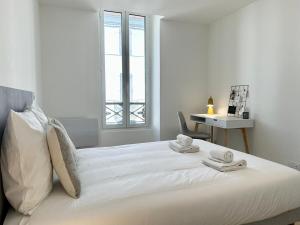 a white bedroom with a bed with towels on it at L'AUTHENTIQUE - Moderne - Central in Mont-de-Marsan +19 photos