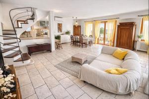 a living room with a couch and a spiral staircase at Casa Nicosandi in Malcesine