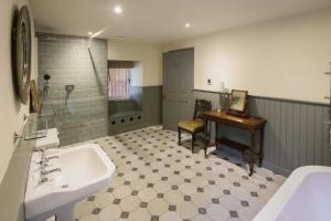 a bathroom with a sink and a desk and a tub at Relugas Mill in Forres +27 photos