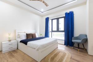 a white bedroom with a bed and a window at Indigo Studio by JadeCaps 1BHK New Town Kolkata in kolkata